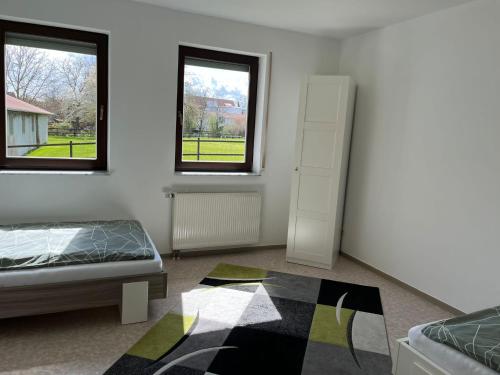 a bedroom with a bed and two windows and a rug at Weingut Sparrmühle Clarissa und Werner Manz GbR in Undenheim