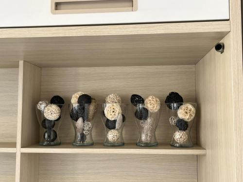 a row of vases on a shelf in a cabinet at Smart Living in Aveiro