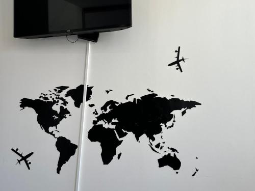 a black world map on a wall with a plane at Smart Living in Aveiro