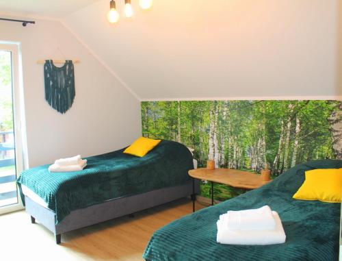 a bedroom with two beds and a window with trees at BetullaHouse in Nakielno