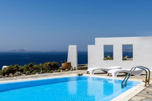 a swimming pool with a view of the ocean at Seablue Villas in Houlakia