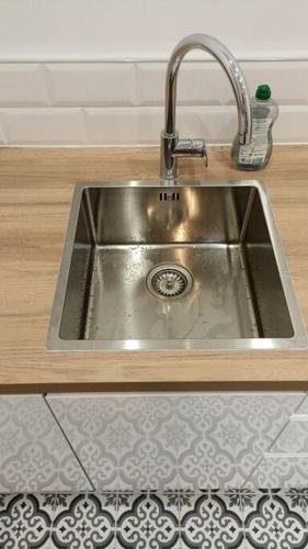 - un évier en acier inoxydable avec un robinet dans la cuisine dans l'établissement Appartement proche Gare Part-Dieu, à Lyon