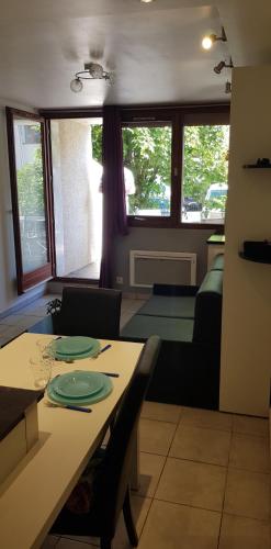 d'un salon avec une table et des plaques de cuisson. dans l'établissement Charmant studio 2* rdc+ terrasse & parking privé, à Aix-les-Bains