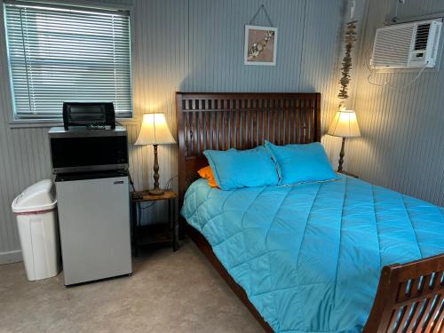 una camera con un letto con lenzuola blu e un computer portatile di Seagull Seaclusion a Sargent