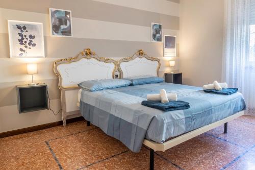 a bedroom with a bed with blue sheets and a tv at Appartamento Ducco zona ospedale in Brescia