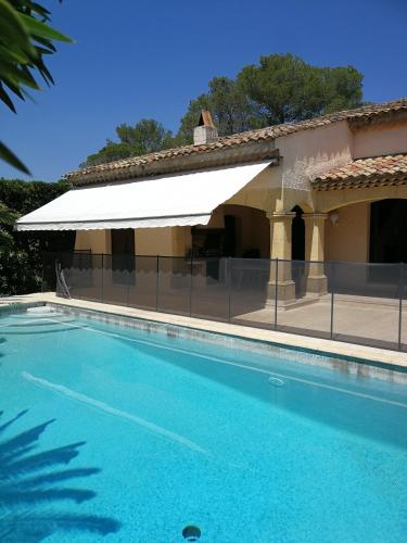 une piscine avec un auvent blanc à côté d'un bâtiment dans l'établissement Villa avec piscine 8 personnes, à Fréjus