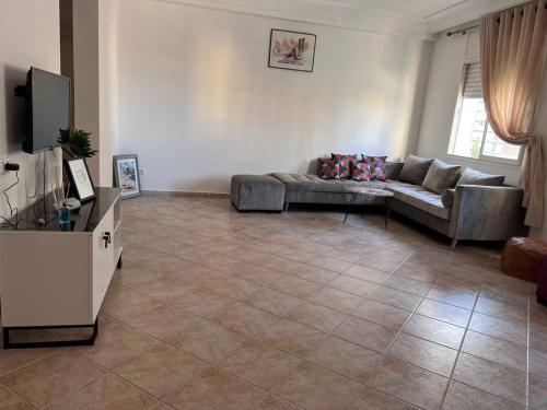 - un salon avec un canapé et une télévision dans l'établissement Appartement luxueux à Rabat, à Rabat