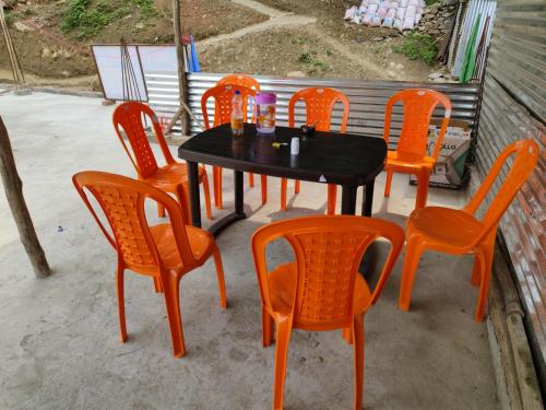 a black table and orange chairs sitting on a patio at Aditya guest House and restaurant in Trijugi Nārāyan