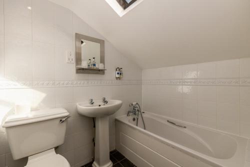 a bathroom with a sink and a toilet and a bath tub at Bower House Inn in Eskdale