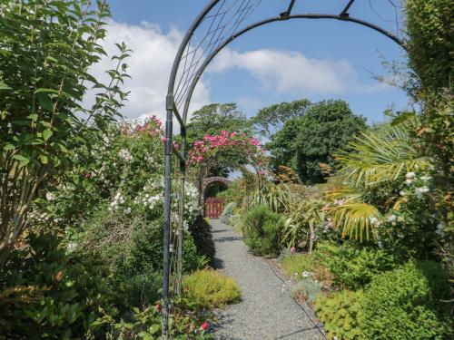 a garden archway in a garden with flowers at No 4 The Shippon in Llangefni
