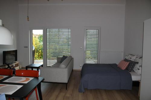 a living room with a bed and a couch at Apartmány Hluboká nad Vltavou s výhledem na zámek in Hluboká nad Vltavou