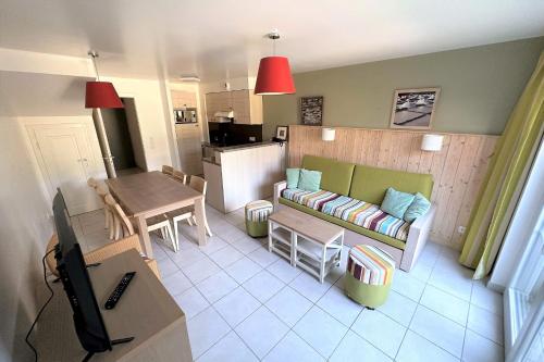 un salon avec un canapé et une table dans l'établissement Quiet bright apartment in Pornichet, à Pornichet