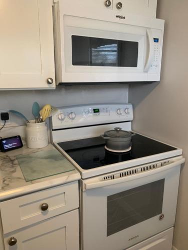 a kitchen with a stove and a microwave at Ormond Beach, fun & loving sun! in Ormond Beach