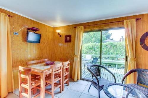 uma sala de jantar com mesa e cadeiras e uma varanda em AmbienteMar Cabañas em Papudo