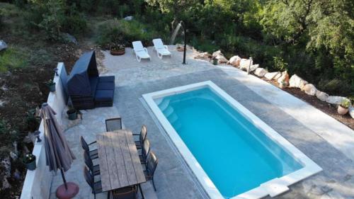 eine Aussicht über einen Pool mit Stühlen und einem Tisch in der Unterkunft Holiday Home Jadrić in Osoje