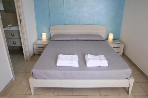 een slaapkamer met een bed met twee handdoeken erop bij Corte Rondine B&B in Presicce