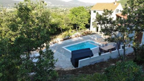 eine Aussicht auf einen Pool vor einem Haus in der Unterkunft Holiday Home Jadrić in Osoje