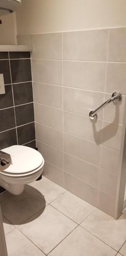 La salle de bains est pourvue de toilettes et d'un mur. dans l'établissement Charmant studio 2* rdc+ terrasse & parking privé, à Aix-les-Bains