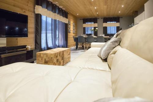 een woonkamer met een witte bank en een tafel bij HaKaJu Appartement 10 personnes à Val Cenis in Lanslebourg-Mont-Cenis