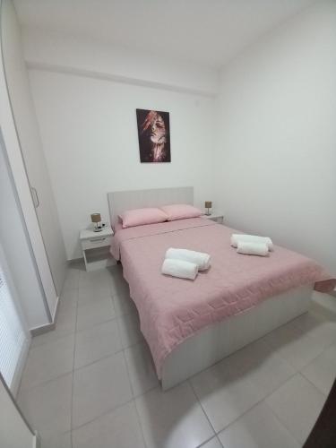 1 dormitorio blanco con 1 cama rosa y 2 almohadas en Stojanović apartman Jagodina, en Jagodina