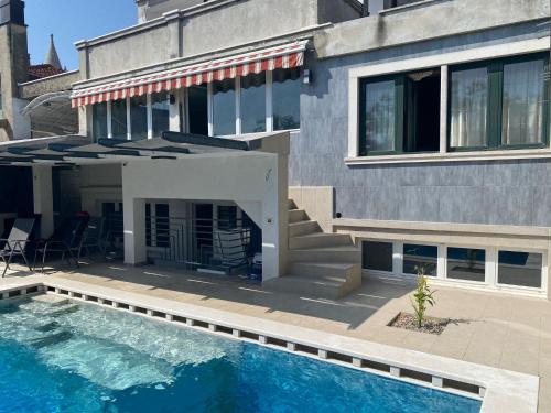 uma casa com piscina em frente a uma casa em Villa Arena - pool table, table tennis, darts, pinball machine & more em Pula