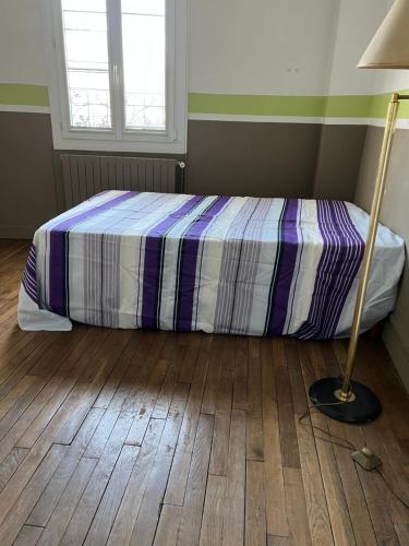 1 dormitorio con 1 cama y 1 lámpara en el suelo de madera en Hapiness, en Sannois