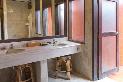 a bathroom with two sinks and a large mirror at Toraja Heritage Hotel in Rantepao