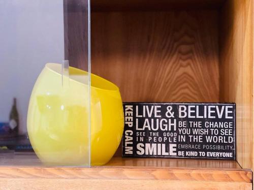 a yellow vase sitting on a shelf with a sign at Studio Mango w/Patio & Parking in Gliwice