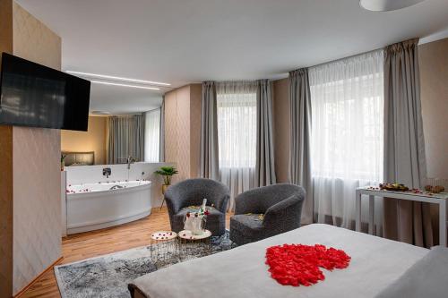 a room with a bath tub and two chairs and a table at Penzion Solid Spa in Mladá Boleslav
