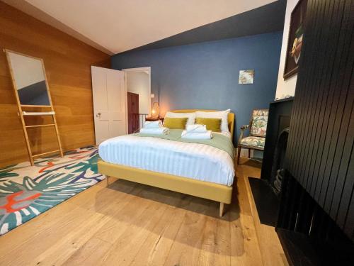 um quarto com uma cama e uma parede azul em Stylish 2-bedroom Townhouse next to Brighton Station em Brighton & Hove