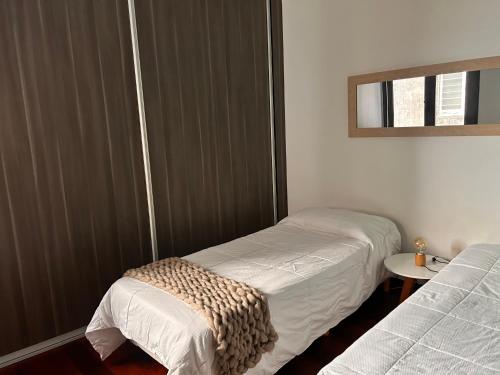 Habitación pequeña con 2 camas y espejo. en Stylish and spacious city center apartment en Rosario