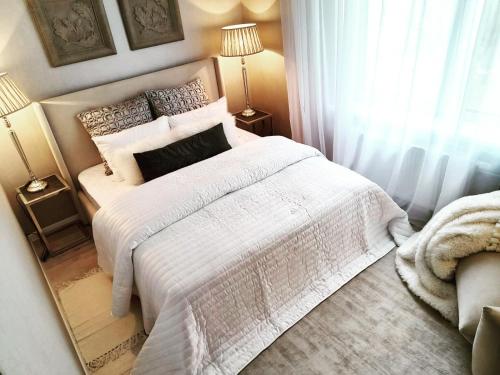 sypialnia z białym łóżkiem i lustrem w obiekcie VB Domum Hospitum w mieście Krasław