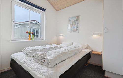 1 cama con sábanas blancas en una habitación con ventana en Marina Fiskens Feriepark, en Gråsten