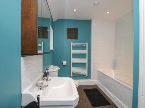 een badkamer met een witte wastafel en een bad bij Ashwood Cottage in Grange Over Sands
