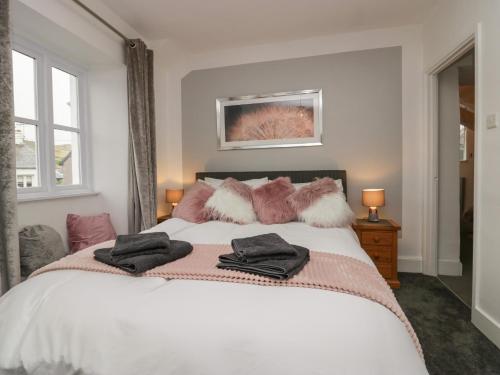 een slaapkamer met een wit bed met kussens erop bij Ashwood Cottage in Grange Over Sands