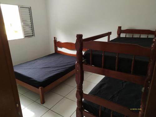 two bunk beds in a room with a window at CASA DE TEMPORADA in Peruíbe