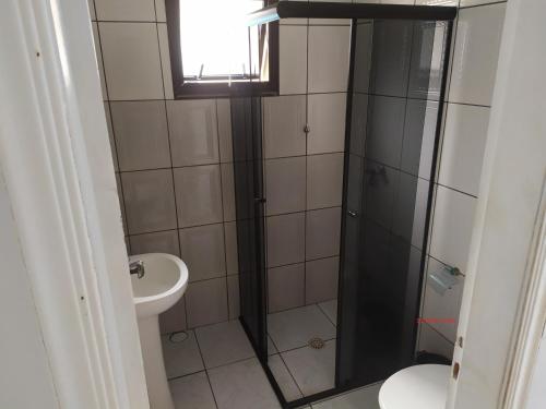 a bathroom with a shower and a toilet and a sink at CASA DE TEMPORADA in Peruíbe