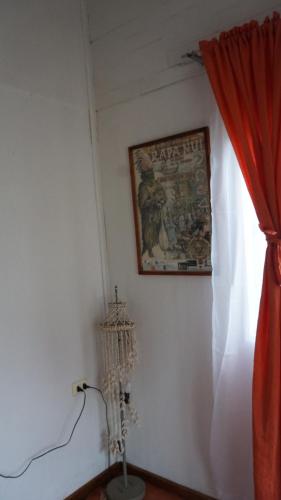 esquina de una habitación con una cortina roja y una foto en Cabañas Isla de Pascua, en Hanga Roa