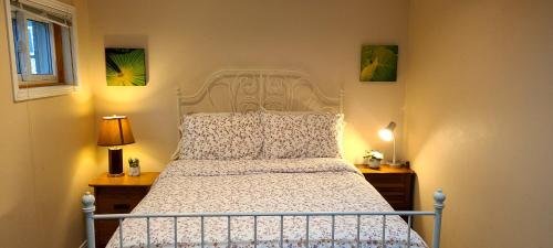 una camera con un letto bianco con due lampade e una finestra di Spacious and bright unit with natural light. a Pickering