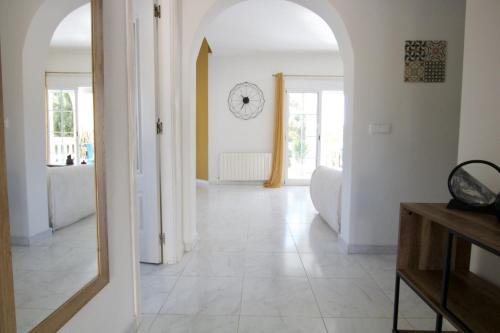 pasillo con espejo y reloj en la pared en Villa Torre, en El Campello