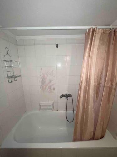a bathroom with a bath tub with a shower curtain at WildCalypso-2- Bedrooms Fully Equipped with Private Parking in Perea