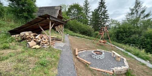 a building with a fire pit in the grass at Malé Milé Áčko in Nižné Malatíny