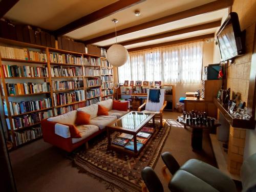 a living room filled with lots of bookshelves at Hotel Boutique La Casa de Margarita in Cochabamba