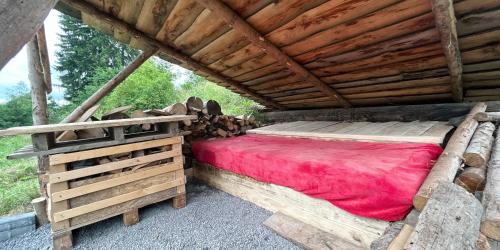 a bed in a log cabin with a wooden roof at Malé Milé Áčko in Nižné Malatíny