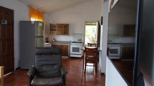 a kitchen with a refrigerator and a chair in it at Cabañas Isla de Pascua in Hanga Roa