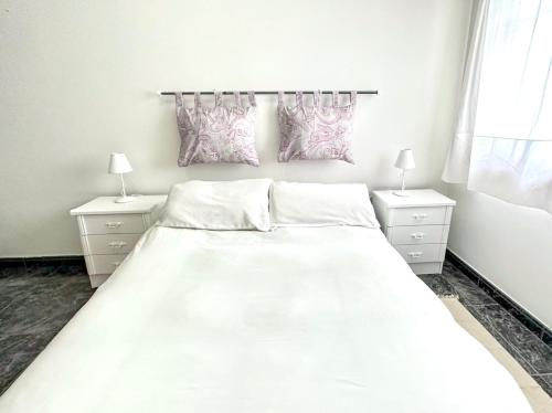 a bedroom with a large white bed and two night stands at Razal in Miño