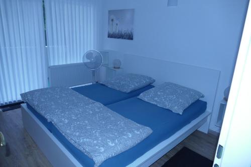 a blue bedroom with two beds with pillows at Ferienwohnung Reese- Horstmann mit Hallenbad und Sauna, WLAN "Harz zu jeder Jahreszeit" in Bad Harzburg