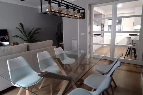 a living room with a glass table and chairs at San Sebastian Centro Parking incluido in San Sebastián