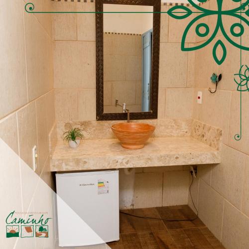 a bathroom with a sink and a mirror at Pousada No Caminho in Tambaú