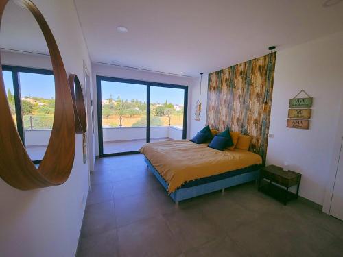 een slaapkamer met een bed en een groot raam bij Villa Sunset in Guia